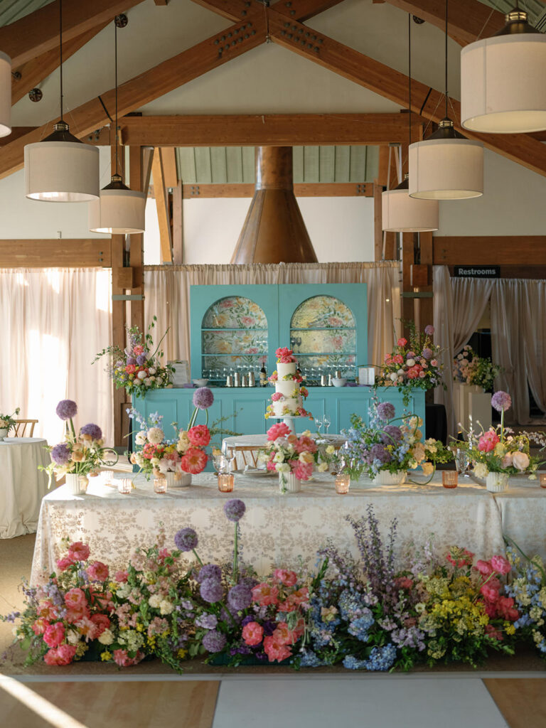 Reception head table with a floral meadow and turquoise bar at a Little Nell Aspen wedding