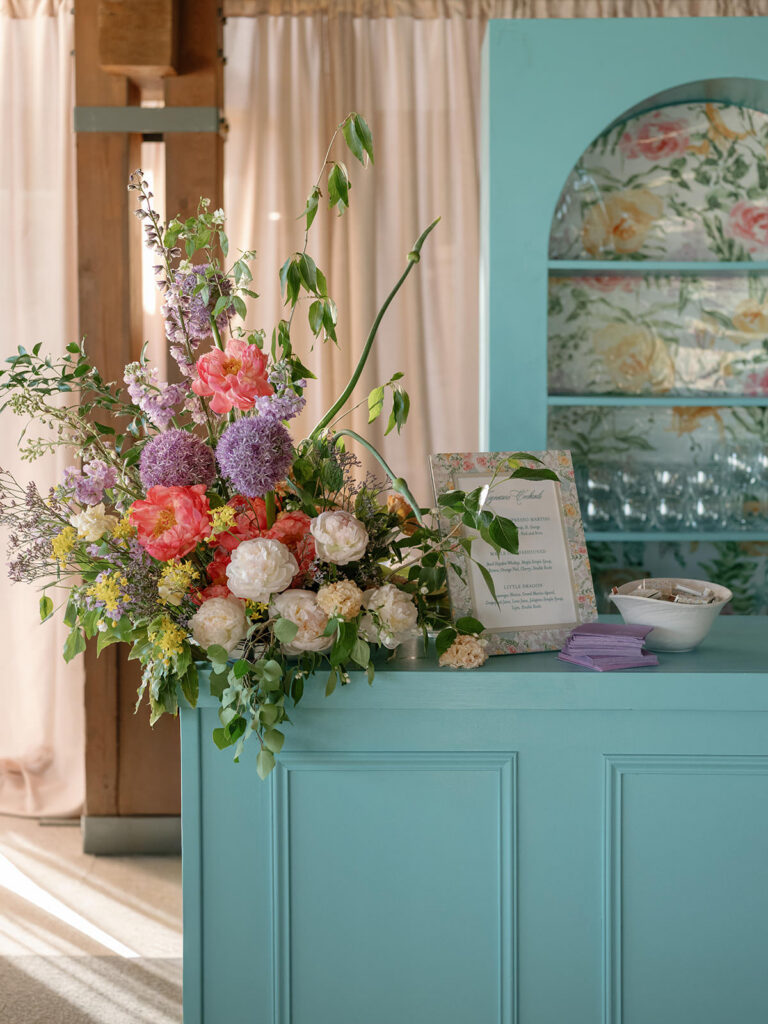 Custom turquoise bar with garden florals and a signature cocktail menu at an Aspen wedding
