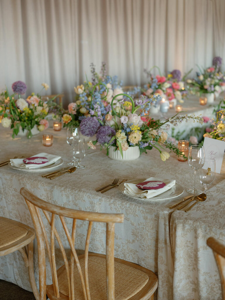 Reception long table with toile linens, gold flatware, and garden centerpieces at The Little Nell